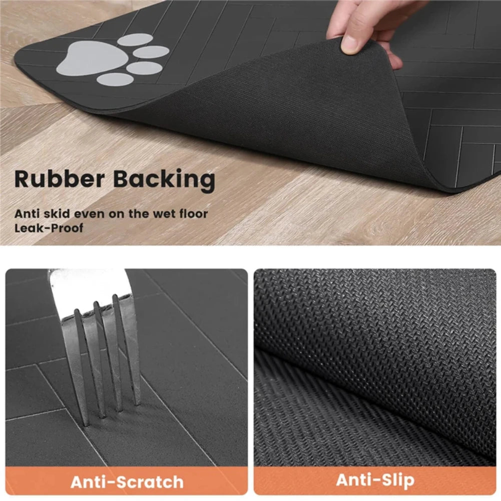 Black pet mat with paw print design on rubber backing, shown on a wooden floor.